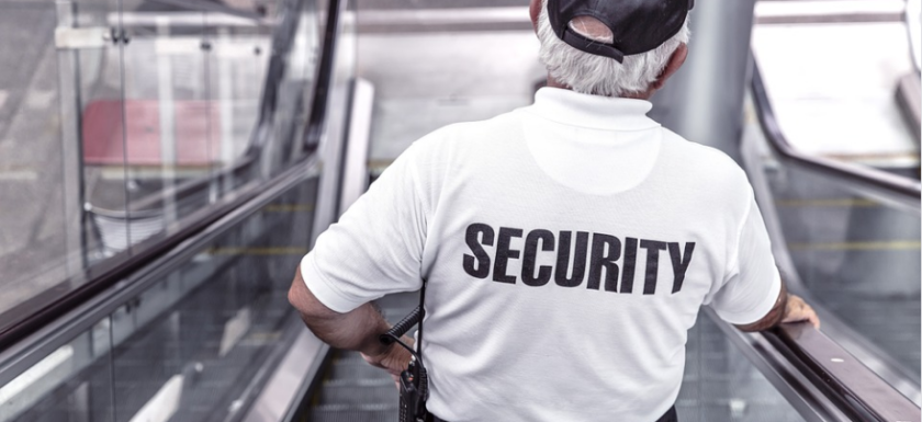 an old security guard standing on the escalator